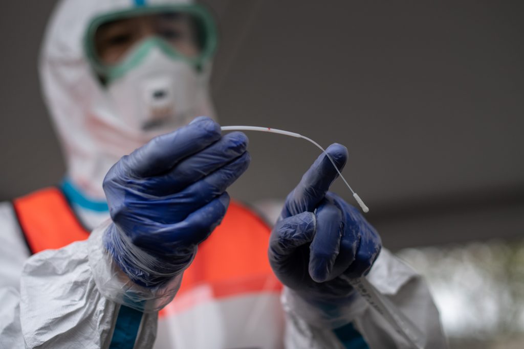 A doctor displays a swab used to test patients during a demonstration of a drive-through PCR swab test for the COVID-19 coronavirus in Fujisawa in Kanagawa prefecture, southwest of Tokyo, April. 27, 2020. (AFP