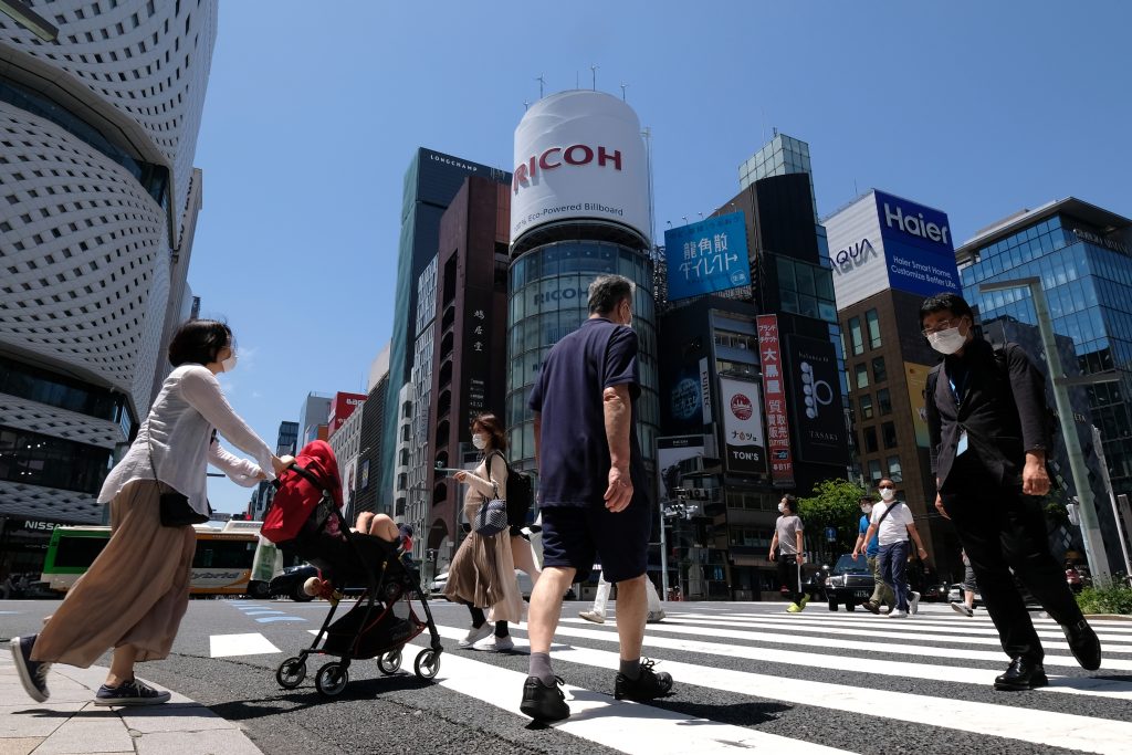 People wearing face masks amid concerns over the spread of the COVID-19 coronavirus cross a street in the Ginza shopping district in Tokyo, May. 17, 2020. (AFP)
