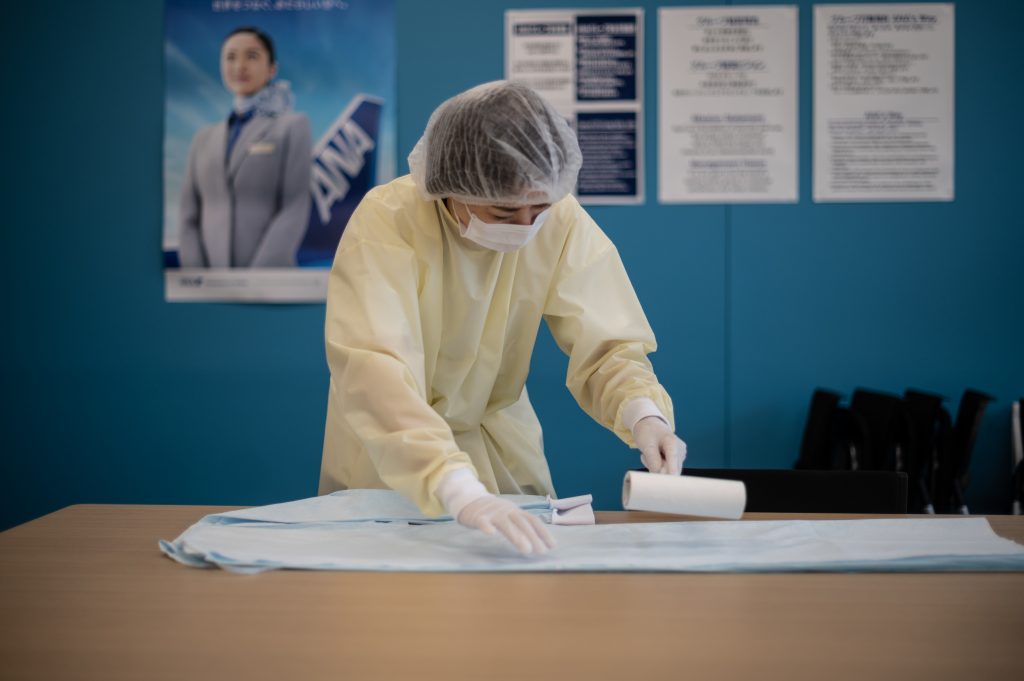 All Nippon Airways staff members make medical gowns in Tokyo on May. 18, 2020. (AFP)