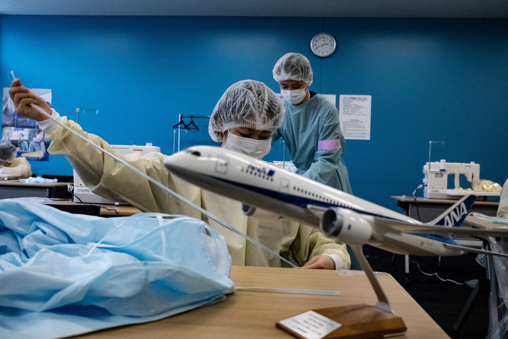 All Nippon Airways staff members make medical gowns in Tokyo on May. 18, 2020. (AFP)