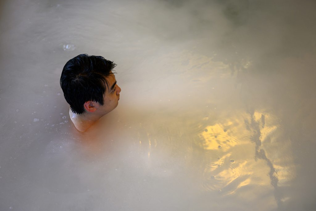 In this picture taken on May 29, 2020, a man relaxes in an indoor pool at a Japanese hot spring or onsen in Yokohama, Kanagawa prefecture. With the lifting of a nationwide state of emergency over the virus, Japan's onsen -- large bathhouses where patrons bathe naked in a series of warm pools and tubs -- are gradually reopening. (AFP)