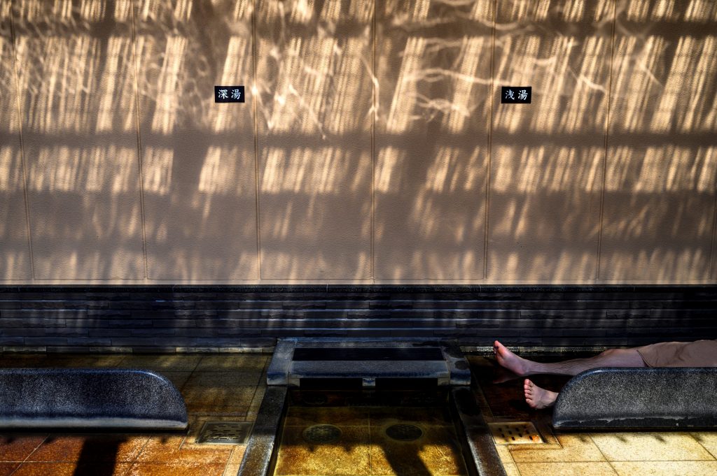 In this picture taken on May 29, 2020, a man relaxes at a Japanese hot spring or onsen in Yokohama, Kanagawa prefecture. With the lifting of a nationwide state of emergency over the virus, Japan's onsen -- large bathhouses where patrons bathe naked in a series of warm pools and tubs -- are gradually reopening. (AFP)