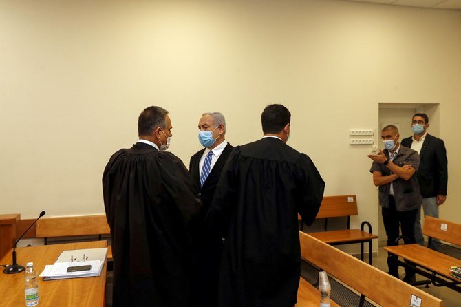 Israeli Prime Minister Benjamin Netanyahu, center, inside a courtroom at the district court of Jerusalem on May 24, 2020, during the first day of his corruption trial. (AFP)