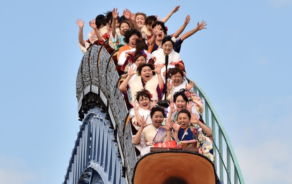 Twenty-year-old women wearing kimonos ride a rollercoaster after attending a