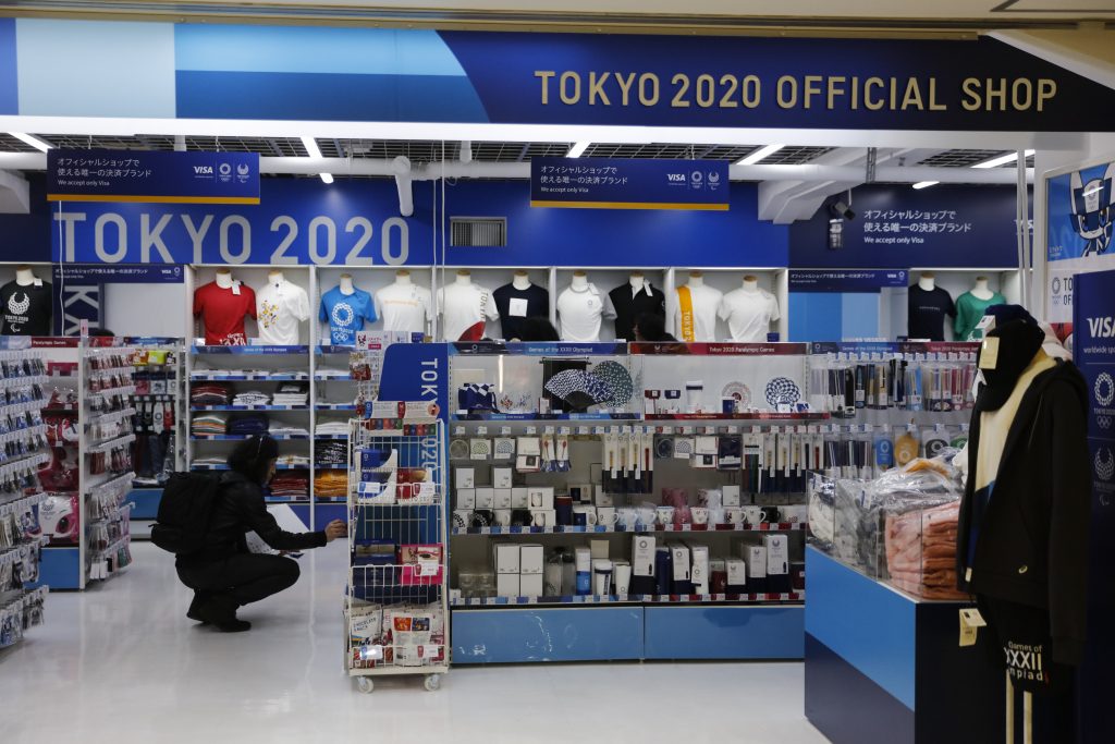 In this Jan. 8, 2020, file photo, a man looks at Olympic souvenirs at a Tokyo 2020 official shop in the Shinjuku district of Tokyo. Official Tokyo Olympic souvenir shops are drawing few customers these days. The pandemic and the fact the Olympics have been postponed for a year has wiped out almost all business. (AP)