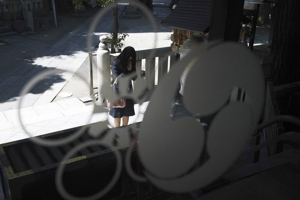 In this May 8, 2020, photo, a visitor prays at Onoterusaki Shrine in downtown Tokyo. The shrine offered a 10-day trial of 