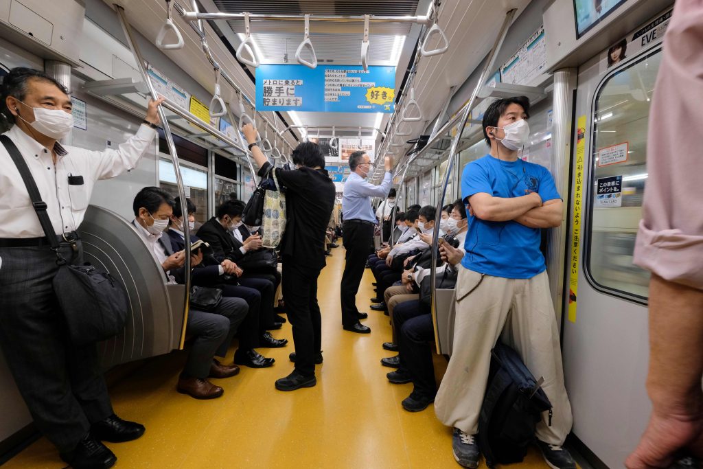 People wearing face masks amid concerns of the COVID-19 coronavirus commute on a train in Tokyo on May. 26, 2020. (File photo/AFP)