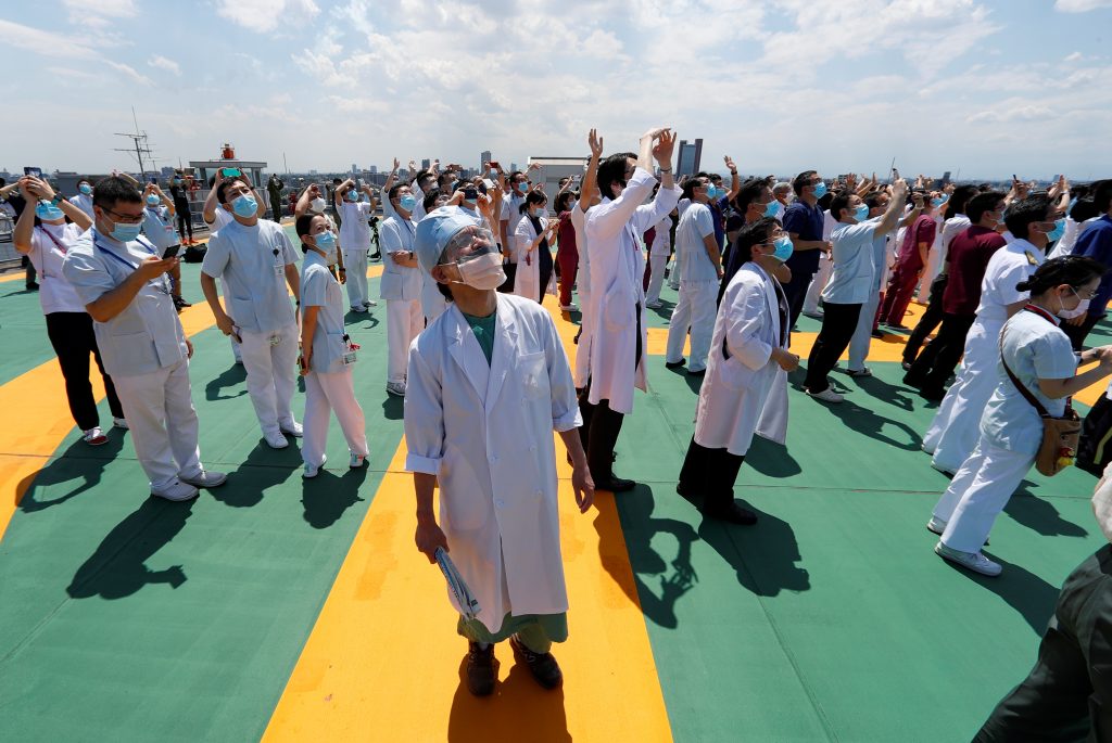 Medical workers watch the 'Blue-Impulse' aerobatic team of Japan Air Self-Defense Force as they fly over the Self-Defense Forces Central Hospital to salute the medical workers at the frontline of the fight against the coronavirus disease (COVID-19) in Tokyo, Japan May 29, 2020. (Reuters)