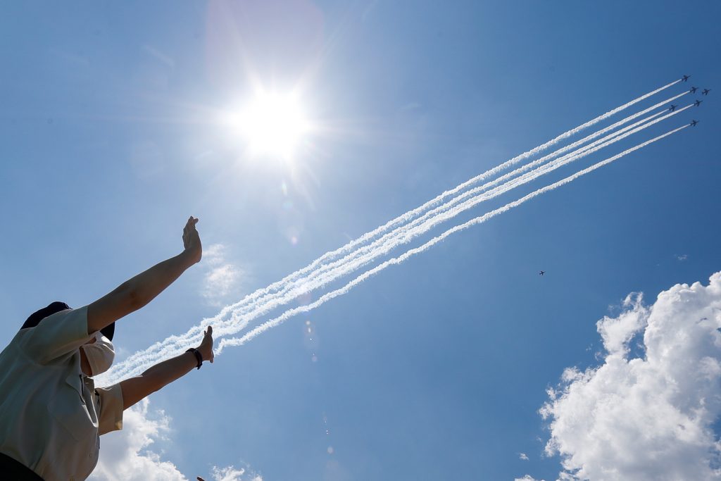 A person gestures as the 'Blue-Impulse' aerobatic team of Japan Air Self-Defense Force flies over the Self-Defense Forces Central Hospital to salute the medical workers at the frontline of the fight against the coronavirus disease (COVID-19) in Tokyo, Japan May 29, 2020. (Reuters)