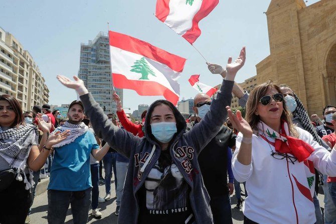 Lebanese anti-government protesters, some wearing protective masks amid the COVID-19 pandemic, gesture during a demonstration against the growing economic hardship in downtown Beirut on May 1, 2020. (AFP)