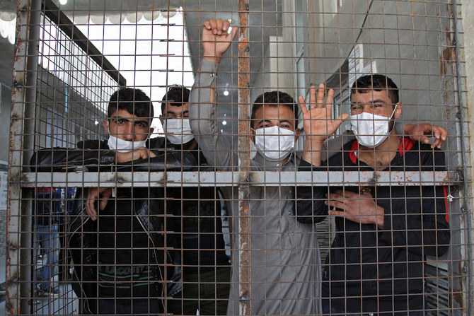 Syrians who returned from Turkey stand at a quarantine facility in the countryside of the town of Jisr al-Shughur, west of the mostly rebel-held Syrian province of Idlib, on April 27, 2020. (AFP)