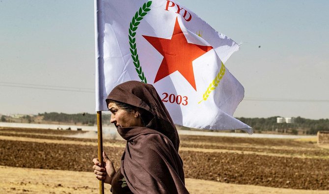 A Syrian Kurdish woman waves the PYD flag in Ras Al-Ain, northern Syria, on Oct. 6 last year. (AFP)