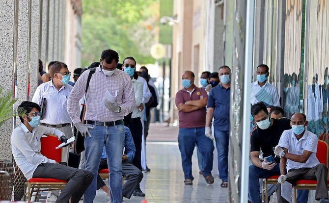 People wearing protective masks queue for services in Qatar’s capital Doha as the country begins enforcing the world’s toughest penalties for failing to wear masks in public while it battles one of the world’s highest coronavirus infection rates. (File/AFP)