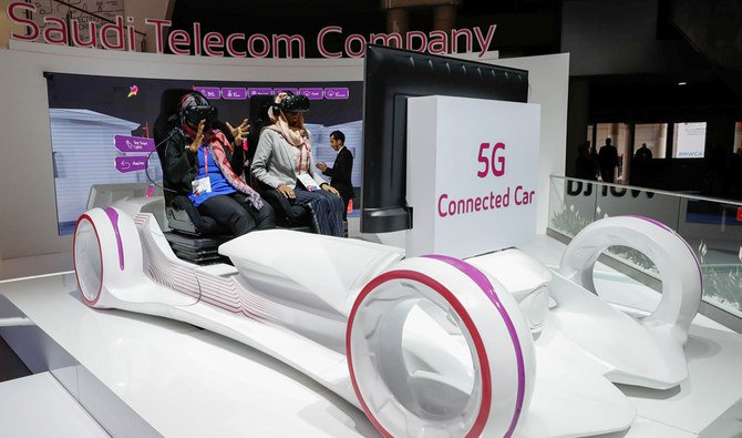 Women sit in a 5G connected car simulator displayed at the Saudi Telecom Company stand during the Mobile World Congress in Barcelona, Spain, February 27, 2018. (REUTERS)