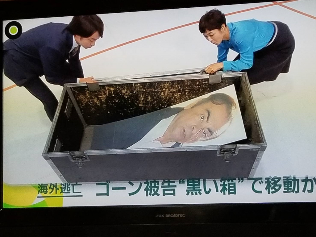 A presenter at a Japanese local TV network and a news cast show a mock box of exact size and similar to the one used by Ghosn to escape border inspectors. (Supplied)