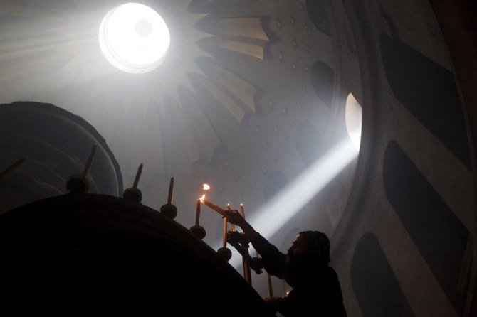 A priest lights candles from the ‘Holy Fire’ at the Holy Sepulcher church in Jerusalem’s old city in this April 3, 2010 picture. (AFP file photo)