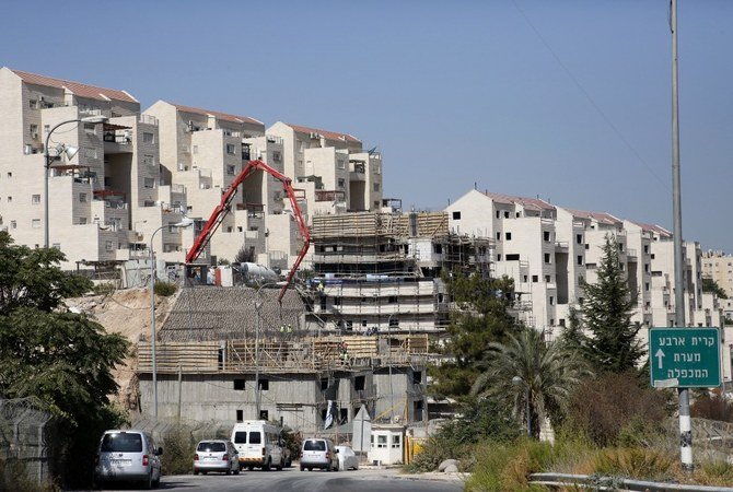 Construction workers build new houses in the Jewish settlement of Kiryat Arba, in the occupied West Bank. (AFP/File)