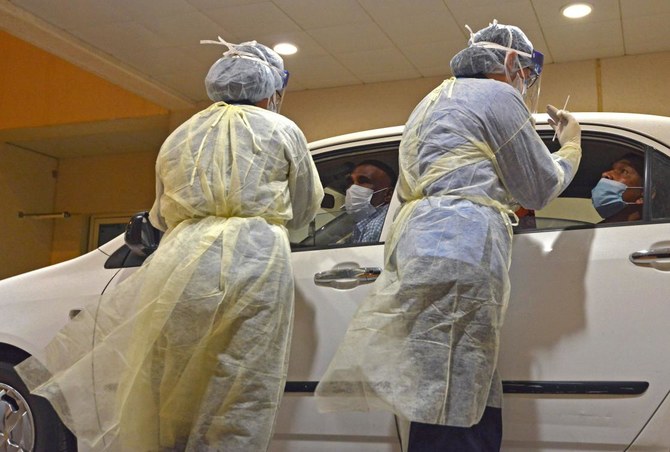 Health workers perform a nose swab test during a drive through coronavirus test campaign held in Diriyah hospital in Riyadh on May 7, 2020. (AFP)