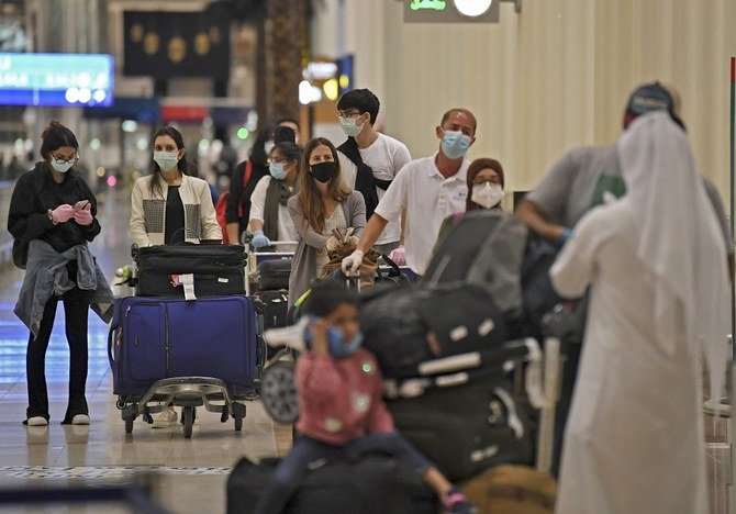 Passengers from an Emirates Airlines flight from London line up before being checked by health workers at Dubai International Airport on May 8, 2020 amid the coronavirus Covid-19 pandemic. (File/AFP)