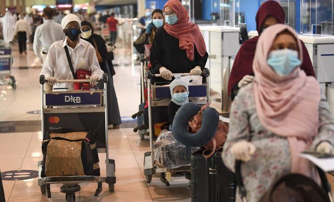 Indian nationals gather at the Dubai International Airport before leaving the Gulf Emirate on a flight back to their country, on May 7, 2020, amid the novel coronavirus pandemic crisis. (AFP)