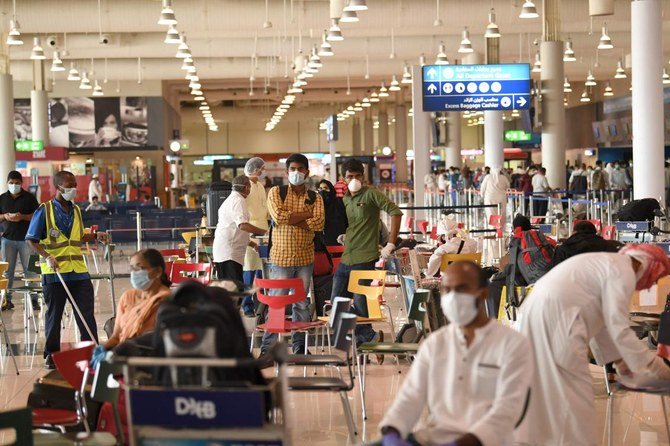 Indian nationals gather at the Dubai International Airport before leaving the Gulf Emirate on a flight back to their country, on May 7, 2020, amid the novel coronavirus pandemic crisis. (AFP)