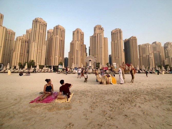 People take photos with camels on the beach at Jumeirah Beach Residence in Dubai, United Arab Emirates, July 17, 2019. (Reuters)
