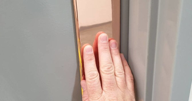 A copper-coated door plate to stop the spread of COVID-19. (Reuters)
