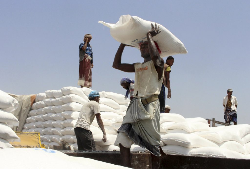 Men deliver U.N. World Food Programme (WFP) aid in Aslam, Hajjah, Yemen. (AP Photo)