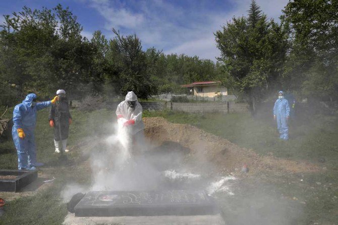 People wearing protective clothing attend the funeral of a victim who died from the new coronavirus, at a cemetery in the outskirts of the city of Ghaemshahr, north Iran, on May 1, 2020. (AP Photo/Ebrahim Noroozi)