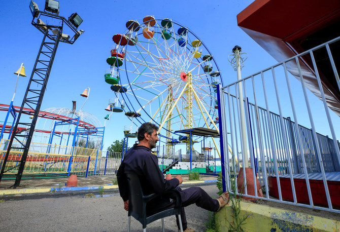 A security guard sits at an empty amusement park, on the first day of the Muslim holiday of Eid Al-Fitr, amid concerns over the spread of the coronavirus disease (COVID-19), in the city of Sidon, southern Lebanon, May 24, 2020. (Reuters)