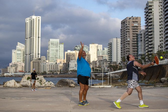 A man welcomes his friend after weeks of a national lockdown to curb the spread of the coronavirus as plays paddleball at Beirut's seaside promenade, along the Mediterranean Sea during the coronavirus pandemic in Beirut, Lebanon, Sunday, May 3, 2020. (AP)