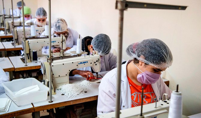 Mask-clad inmates produce protective masks due to the ongoing COVID-19 pandemic, at the Oukacha prison in Casablanca on May 18, 2020. (AFP)