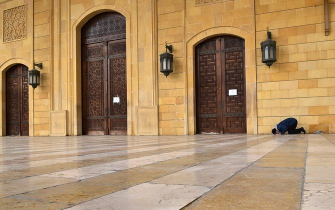 A sole worshipper performs prayers at the entrance of the closed Mohammed Al-Amin Mosque in Beirut, Lebanon, on March 20. (AFP)