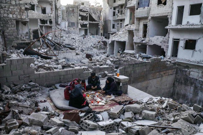 This picture taken on May 4, 2020 during the Muslim holy fasting month of Ramadan shows members of the displaced Syrian family of Tariq Abu Ziad, from the town of Ariha in the southern countryside of the Idlib province, breaking their fast together for the sunset 