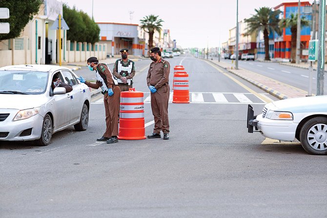 Police enforcing the curfew order check a motorist along a road in Tabarjal town in the northwestern Saudi province of Al-Jouf on Wednesday. (SPA)