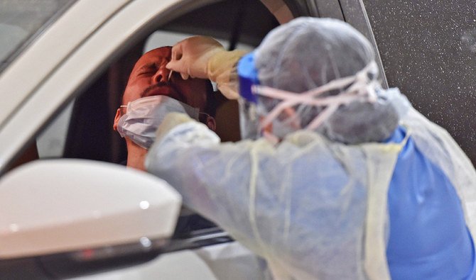 Health workers perform nose swab tests during a drive through coronavirus test campaign held in Diriyah hospital in the Saudi capital Riyadh on May 7, 2020 amid the COVID-19 pandemic. (AFP)
