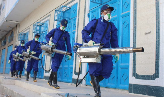 Sanitary workers prepare to perform a fumigation in an area in Yemen's southern coastal city of Aden on May 3, 2020, as part of a campaign to prevent insect-borne diseases amidst the COVID-19 coronavirus pandemic. (AFP)