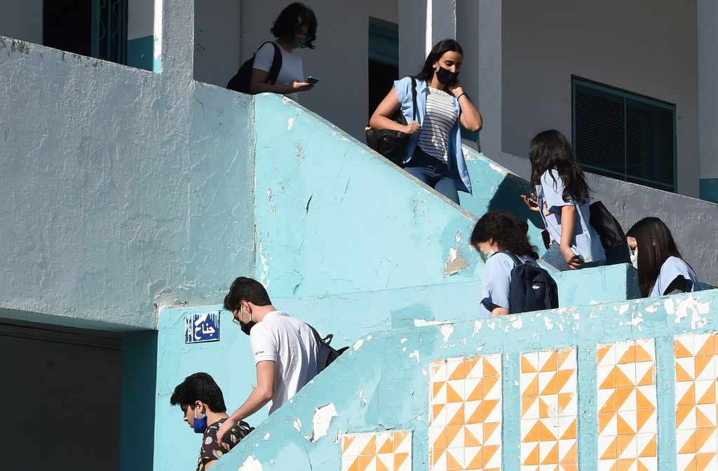 Tunisian highschool students wearing face masks are pictured at their school in Tunisia's capital Tunis on May 28, 2020 after authorities approved the easing of measures put in place due to the COVID-19 coronavirus pandemic. (AFP)