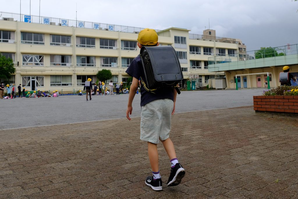 An elementary school student wearing a face mask amid concerns over the spread of the COVID-19 coronavirus arrives at a reopened school in Tokyo, June. 1, 2020. (AFP)