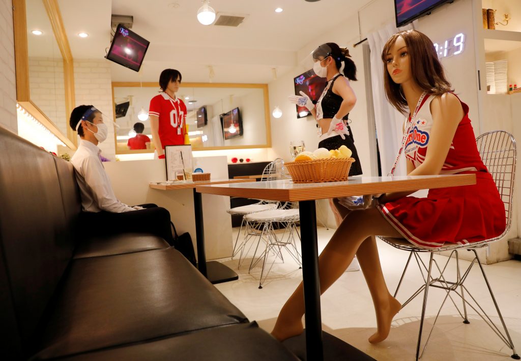 A waitress talks to a customer next to mannequins, wearing cheerleader-outfits, placed for social distancing amid the coronavirus disease (COVID-19) outbreak at the cheerleader-themed restaurant 'Cheers One' in Tokyo, Japan June 3, 2020. Picture taken June 3, 2020. (Reuters)
