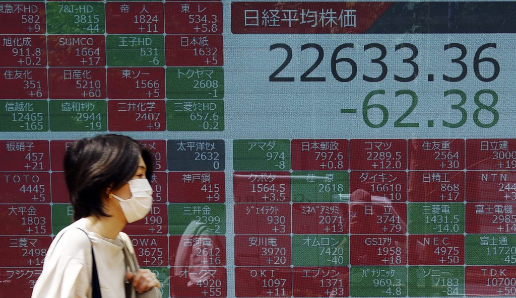 A woman walks past an electronic stock board showing Japan's Nikkei 225 index at a securities firm in Tokyo, June. 5, 2020. (File photo/AP)