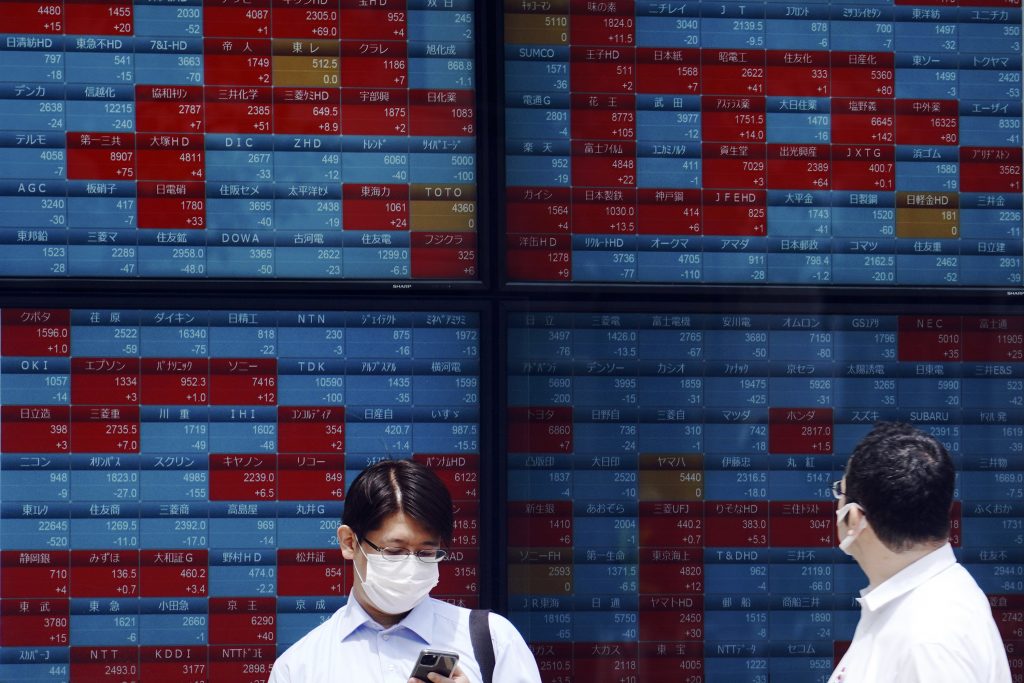 Men stand in front of an electronic stock board showing Japan's Nikkei 225 index at a securities firm in Tokyo Monday, June 15, 2020. Asian shares were mostly lower Monday on concern over a resurgence of coronavirus cases and pessimism after Wall Street posted its worst week in nearly three months. (AP Photo)