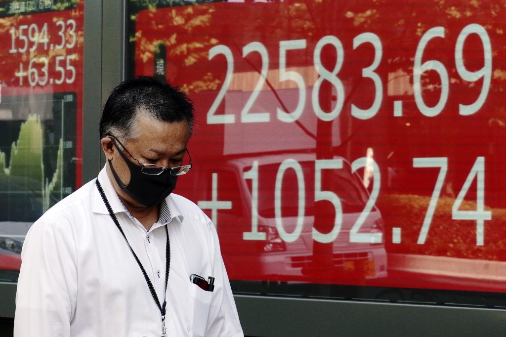  A man walks past an electronic stock board showing Japan's Nikkei 225 index at a securities firm in Tokyo, Tuesday, June 16, 2020. (File photo/AP)