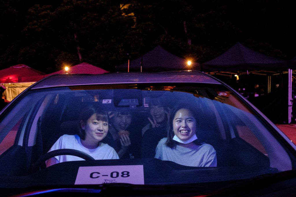 People look out from their car underneath Tokyo tower during a drive-in theatre event in Tokyo on June 20, 2020, amid social restrictions during the COVID-19 coronavirus pandemic. (AFP)