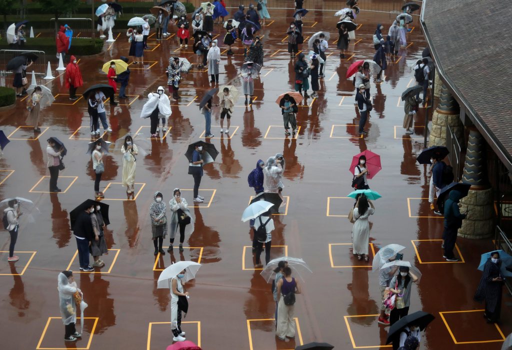 Visitors practicing social distancing while waiting to enter Tokyo Disneyland on July 1. (File photo/ Reuters)