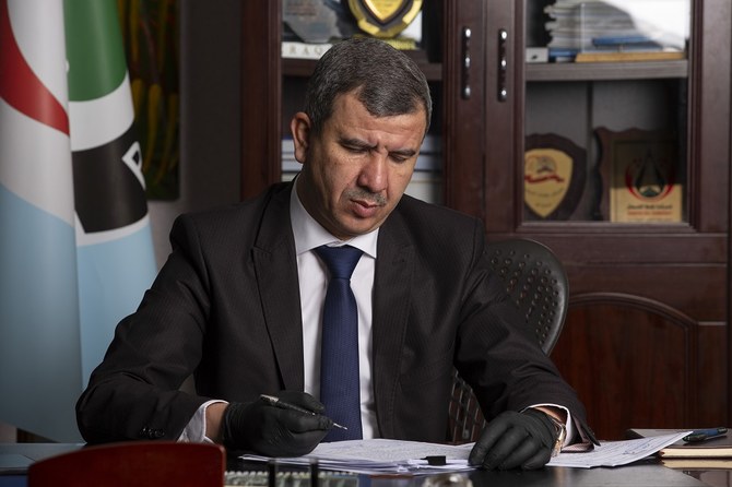 Newly-appointed Iraqi Minister of Oil Ihsan Jabbar reads documents at the Basra Oil Company in Iraq's southern port city, on May 9, 2020. (File/AFP)