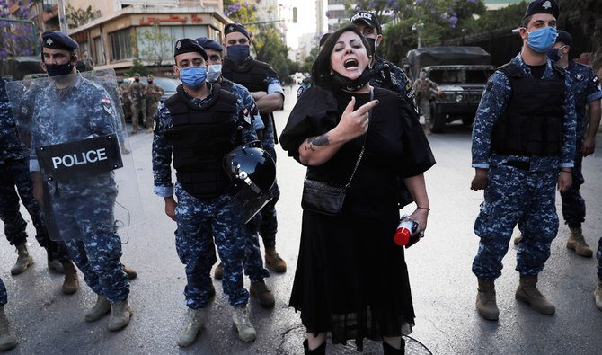 An anti-government protester shouts slogans in front of riot policemen during a protest in Beirut, Lebanon, Friday, May 29, 2020. (AP)