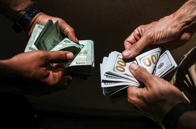 People exchange Lebanese pound and US dollar notes on the black market in Lebanon’s capital Beirut on June 18, 2020. (AFP)