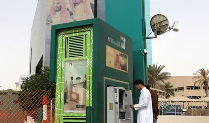 A customer withdraws cash at an NCB ATM in Riyadh. (Reuters)