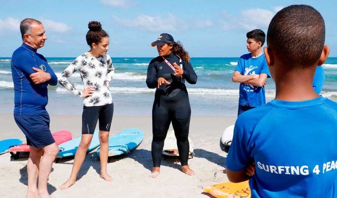 Arab-Israeli Hamama Jarban (C), 41, a lifeguard fisherman and surf teacher, gives surf lessons to teenagers and adults on June 12, 2020 on the beach in the coastal village of Jisr al-Zarqa, north of Tel Aviv. (AFP)